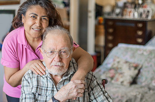 Elderly with caregiver sitting on couch