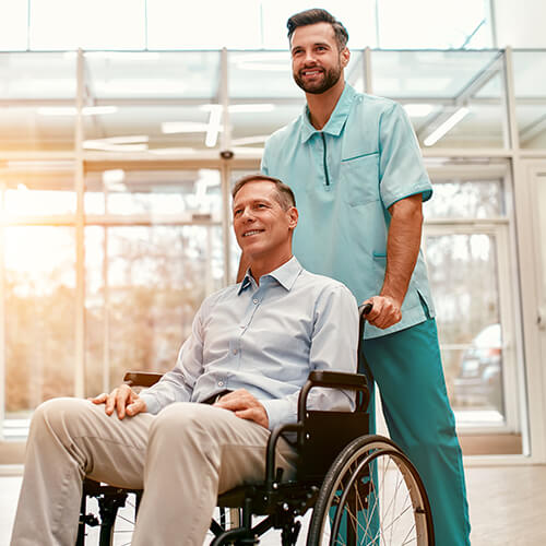 Male caregiver with elderly on wheelchair